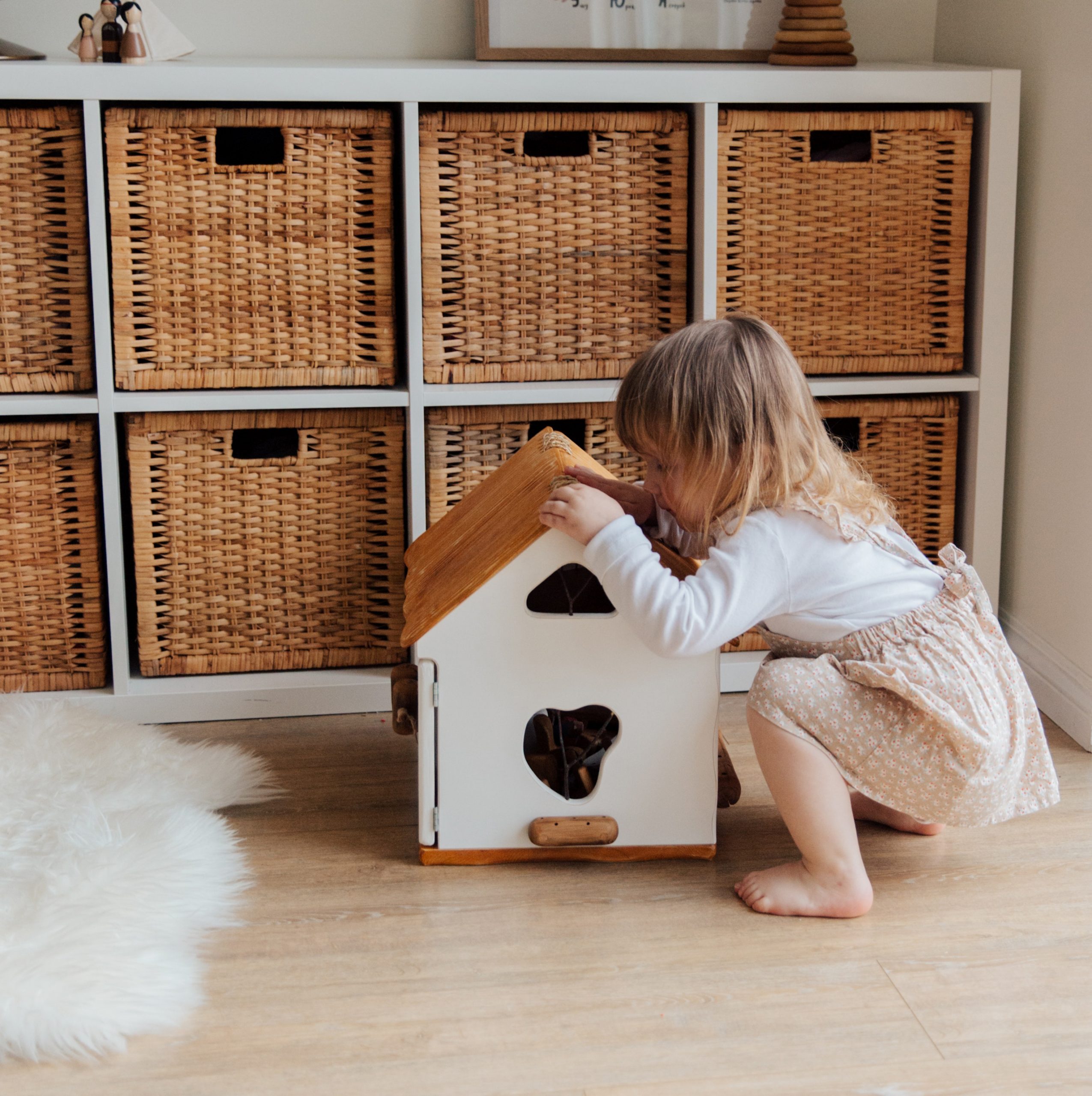 Bambina che gioca con casetta di legno